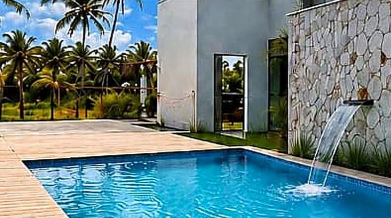Piscina privativa com cascata e parede de pedra