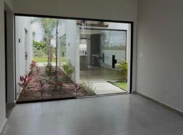 Sala integrada ao jardim por envidraçamento do piso ao teto