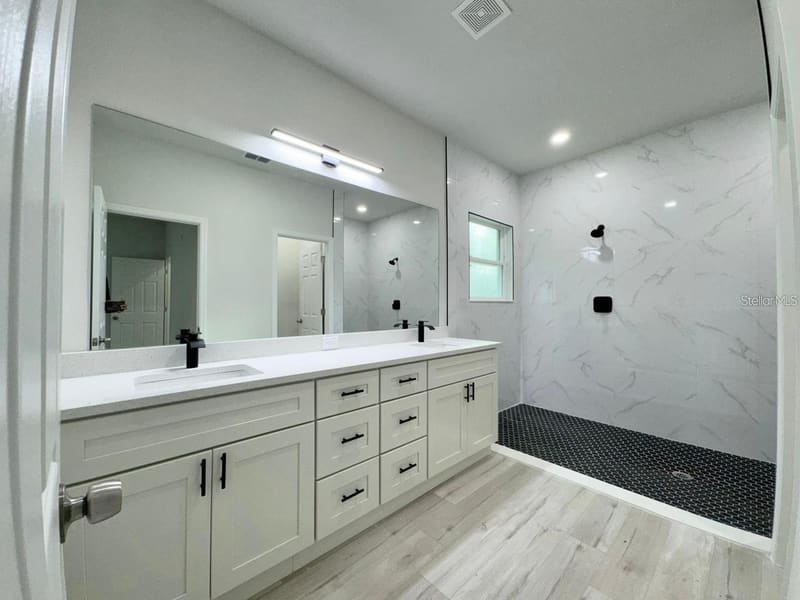Primary bathroom with dual sinks and walk-in shower